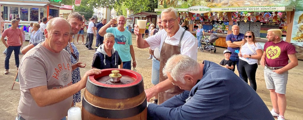 Parkfesteröffnung mit Faßbieranstich in Tangerhütte: Henry (links) und Werner Jacob (rechts) vom Altmärkischen Schaustellerverein sponserten das Freibierfass, Ortsbürgermeister Gerhard Borstell übernahm das Anzapfen.