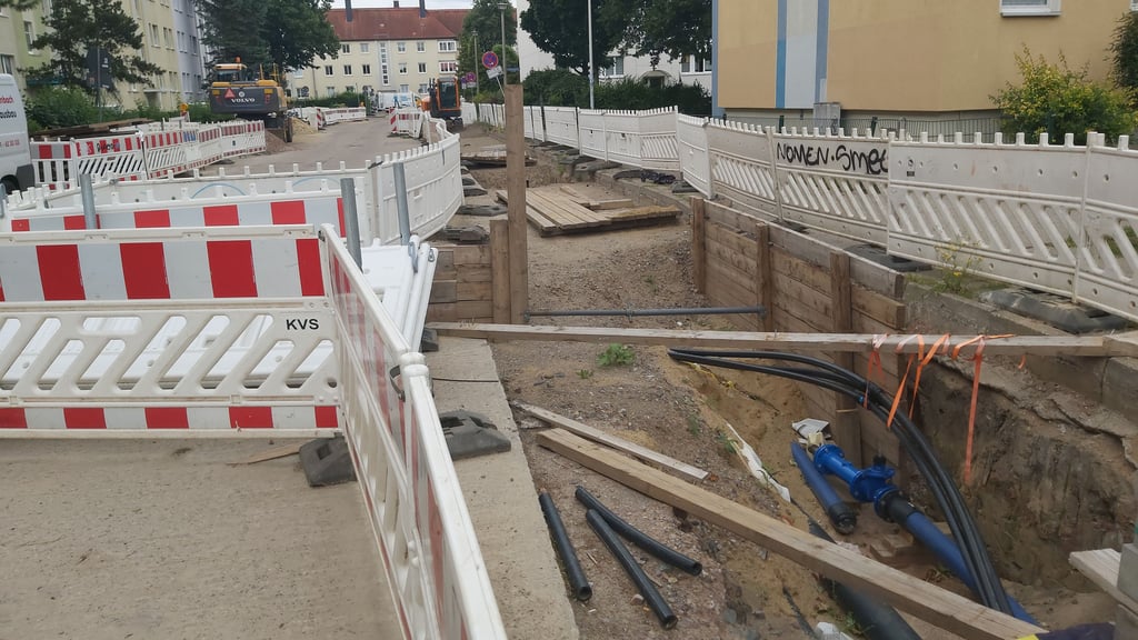 Eine Straße in Magdeburg ist aufgerissen, um Leitungen für Fernwärme und Trinkwasser zu verlegen. Doch es geht nicht voran, weil die Arbeiter fehlen.