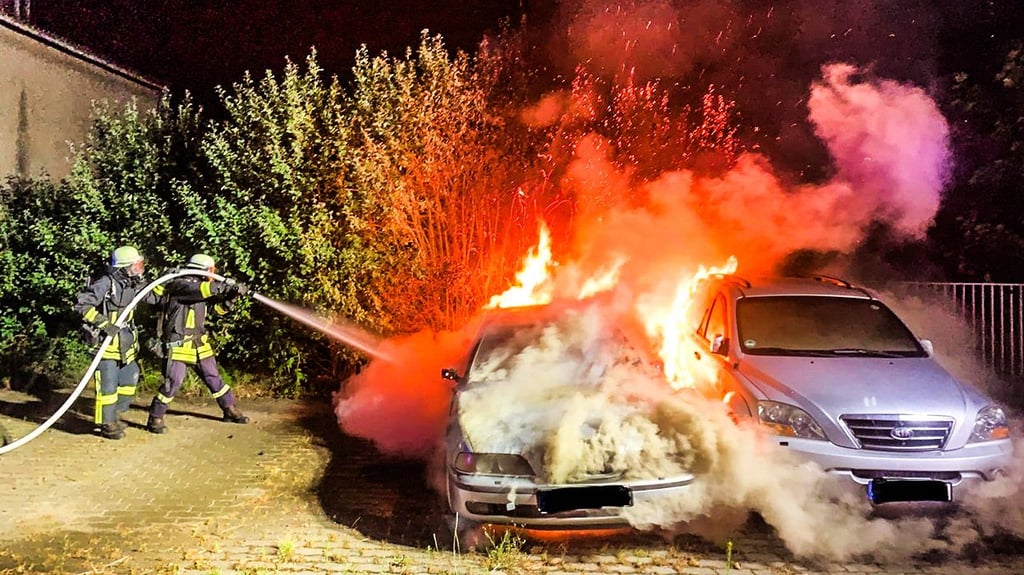 Feuerwehrleute löschen in der Nacht vom 6. auf den 7. Juli 2025 zwei brennende Autos in Werben (Elbe).