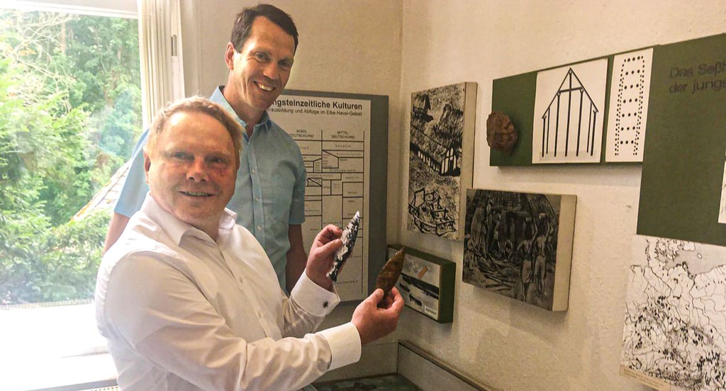 Die Landräte Steve Kanitz (vorn) und Steffen Burchhard bei der Übergabe des Feuersteindolches an das Genthiner Museum.