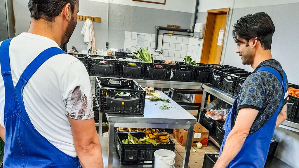 Naser Habibi (r.) und seine Kollegen helfen bei der Lebensmittelsortierung für die Tafel in Merseburg.