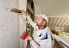 Andreas Bergmann tapeziert einen Raum im Dachgeschoss
