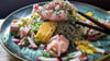 Der Glasnudelsalat mit Lachs-Ceviche wird mit gerösteten weißen und schwarzen Sesamkörnchen getoppt.