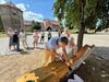Detlef Rutzen schraubt, Claudia und Axel Lundbeck schauen zu auf dem idyllischen Hof des Burchardiklosters Halberstadt.
