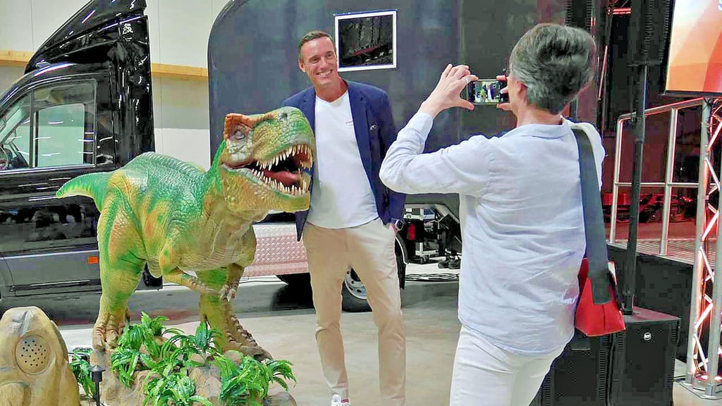 Geschäftsführer Sven Streiff posiert an einem T-Rex in der Lagerhalle in Harbke.