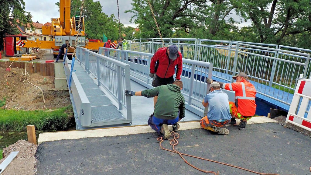Zentimetergenau wird die Ersatz-Stahlbrücke auf den Widerlagern über der Ilse in Osterwieck ausgerichtet.