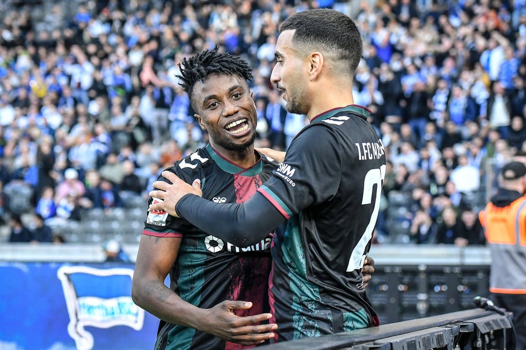 Livan Burcu (re.) feiert Lubambo Musondas Tor beim Spiel des 1. FC Magdeburg gegen Hertha BSC.
