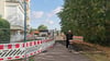 Ein Holzprovisorium in Form einer Brücke über ein Abwasserbauwerk leitet die Füßgänger an der neuen Baustelle an der Elbe in Magdeburg vorbei. Radfahrer müssen absteigen. 
