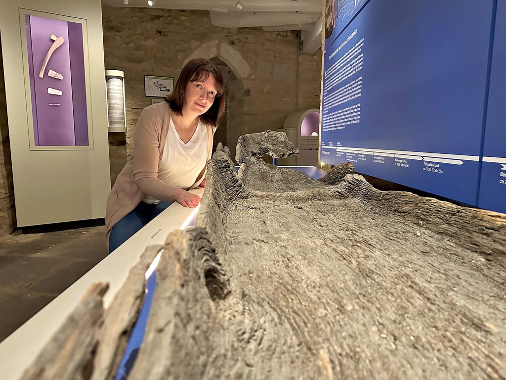 Museumsleiterin Christiane Heinevetter zeigt das größte Ausstellungsstück im Bernburger Museum im Schloss. Es ist ein Einbaum, der einst an der Saale gefunden wurde.
