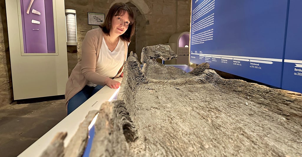 Museumsleiterin Christiane Heinevetter zeigt das größte Ausstellungsstück im Bernburger Museum im Schloss. Es ist ein Einbaum, der einst an der Saale gefunden wurde.