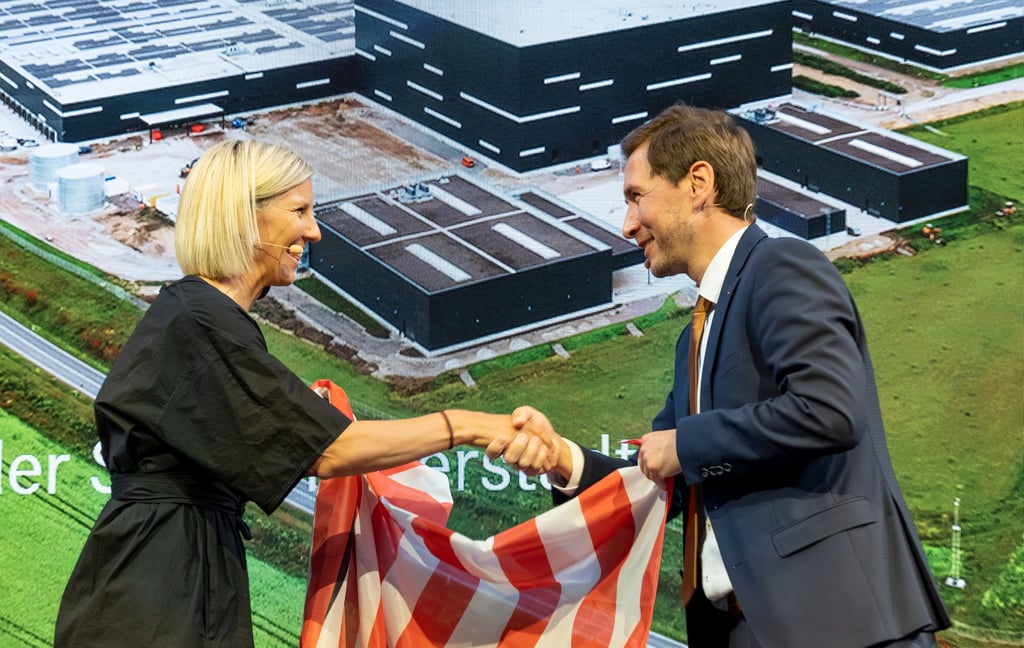 Karin Rådström, Vorstandschefin von Daimler Truck, bekommt von Halberstadts Oberbürgermeister Daniel Szarata die Halberstadt-Fahne, mit der bei der Ansiedlungsverkündung am 13. Januar 2023 eine Lkw-Schürze im Rathaus verhüllt worden war.