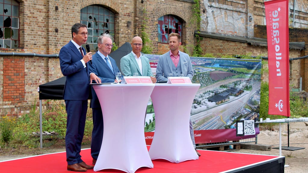 Sprachen vor eindrucksvoller Industriekulisse über große Pläne: Oberbürgermeister Alexander Vogt, Ministerpräsident Reiner Haseloff, Weinberg-Campus-Chef Ulf-Marten Schmieder und Entwicklungsmanager Robert Weber (von links).