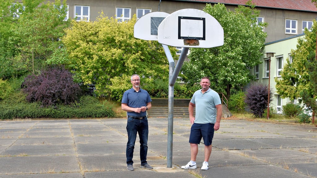 Annaburgs Bürgermeister Stefan Schmidt sowie Mitarbeiter im Bauamt Peter Kerz auf dem Platz, der für einen Neubau der Turnhalle infrage kommt.