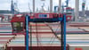 Ein Hubwagen fährt zwischen Containern im Hamburger Hafen umher. (Archivbild)