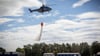 Ein Hubschrauber der Bundespolizei wirft bei einer Waldbrandübung Wasser aus einem Löschwasserbehälter ab.