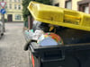 Eine übervolle Gelbe Tonne in Magdeburg am Straßenrand.
