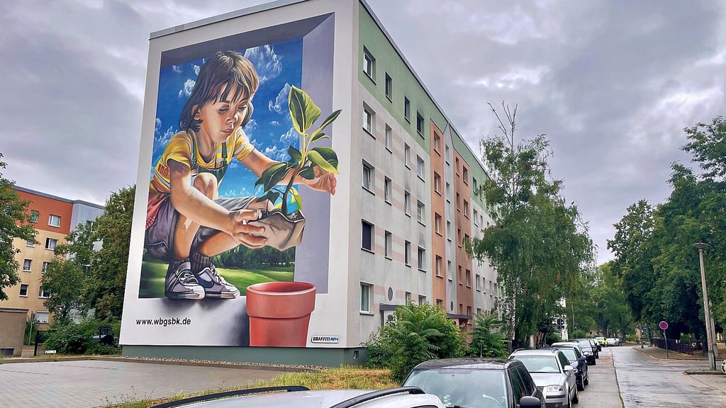 Buntes Graffito statt grauem Einheitsgiebel: Nach dem Abriss eines WBG-Hauses entstanden Parkflächen und eine bemalte Hauswand.