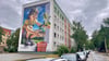 Buntes Graffito statt grauem Einheitsgiebel: Nach dem Abriss eines WBG-Hauses entstanden Parkflächen und eine bemalte Hauswand. 