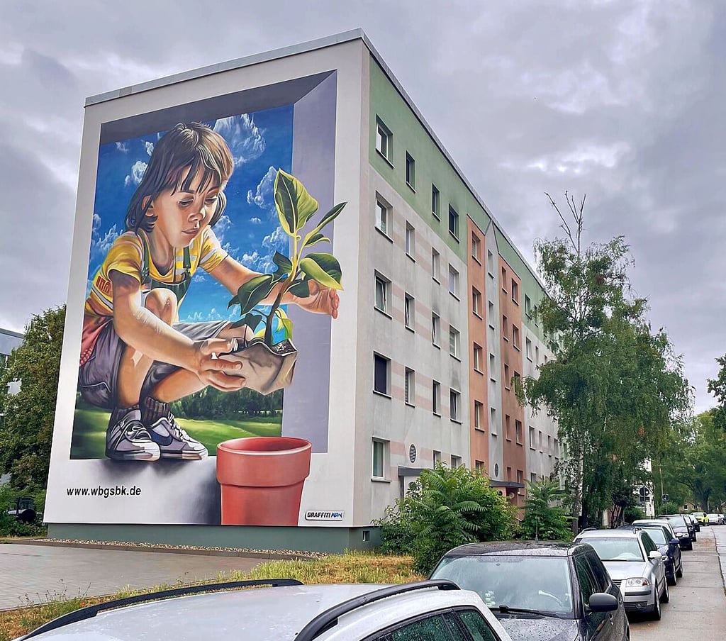Buntes Graffito statt grauem Einheitsgiebel: Nach dem Abriss eines WBG-Hauses entstanden Parkflächen und eine bemalte Hauswand.