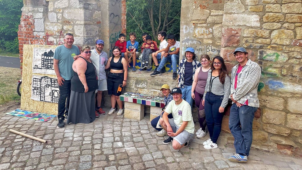 Die Teilnehmer des Sommerkunstcamps auf dem Abschlussfoto in der alten Brückenmühle mit einer der neu gestalteten Bänke
