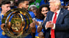 Chelseas Kapitän Reece James (l/vorn) hält auf dem Siegerpodest die Trophäe in den Händen und schaut irritiert zu US-Präsident Donald Trump.