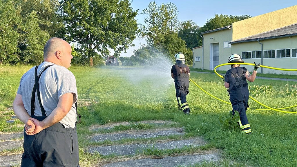 Ausbilder Fabian Manecke (links) von der Freiwilligen Feuerwehr Döbbelin schaut, ob die Kameraden der Feuerwehr Insel bei der Übung zum Löschen eines Flächenbrandes richtig vorgehen.