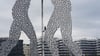 Polizisten kletterten auf die Skulptur „Molecule Man“, nachdem dort Aktivisten ein Banner angebracht hatten.