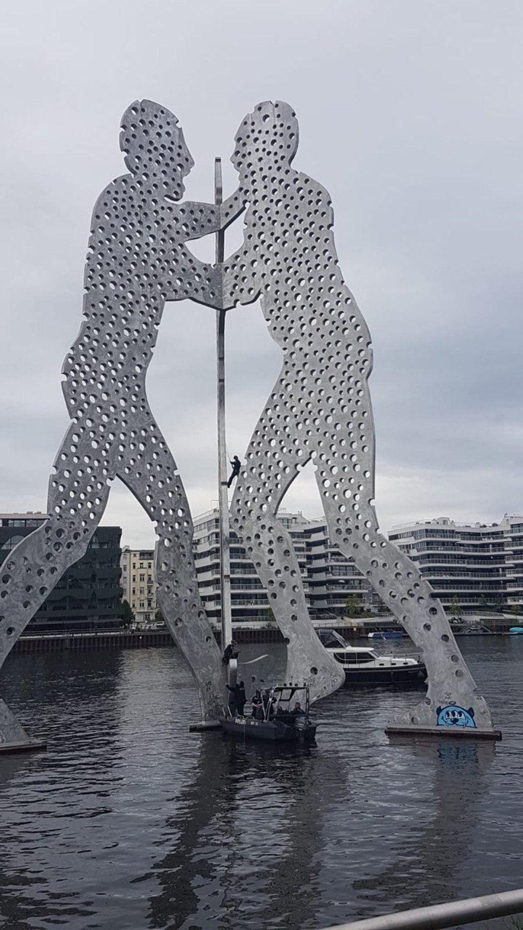 Polizisten kletterten auf die Skulptur „Molecule Man“, nachdem dort Aktivisten ein Banner angebracht hatten.