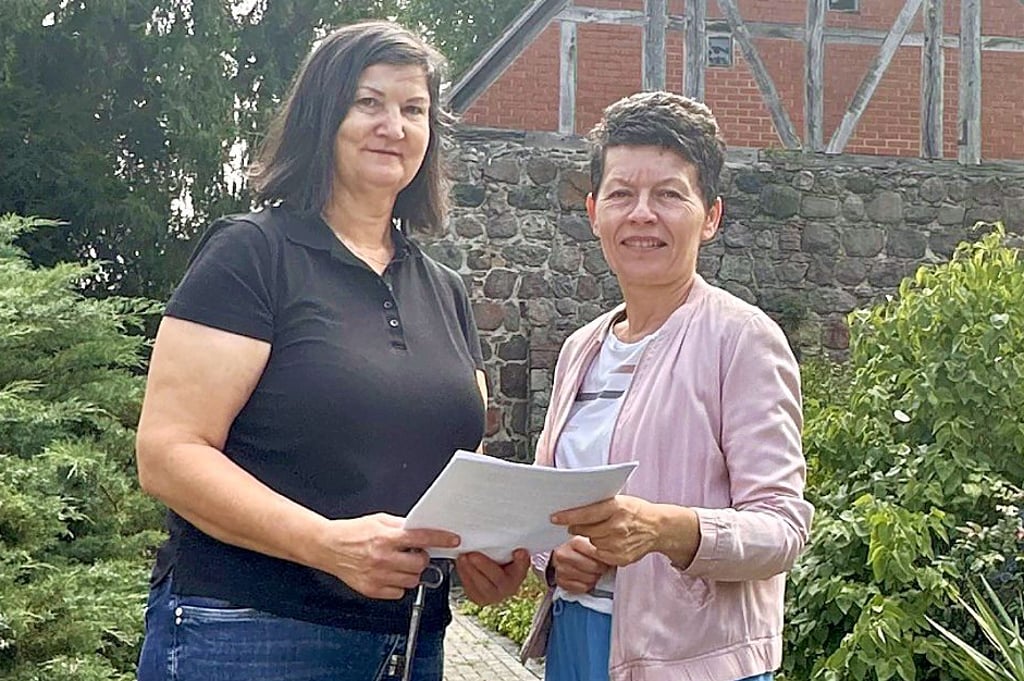 Karina Ueckert und Birgit Rose vom Gemeindekirchenrat vor der Reesener Feldsteinkirche.
