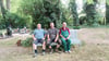 Ortsbürgermeister Ricardo Dunker und die Ortschaftsräte Tim Baronat und Uwe Krebs (von links) sitzen auf einer Bank auf Dedelebens Friedhof.