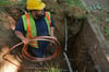 Ein Arbeiter verlegt eine neue Wasserleitung. Ein solcher Austausch in Salzwedel sorgt jetzt für Ärger.