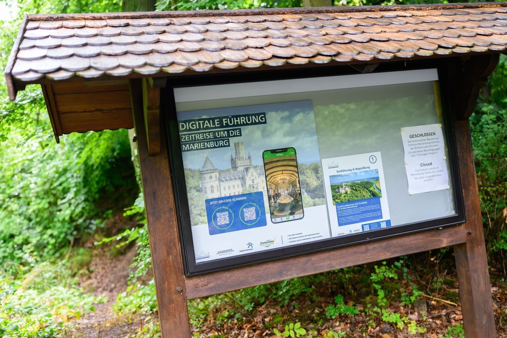 Ein Schild weist auf eine digitale Führung per Smartphone am Schloss Marienburg in der Region Hannover hin.