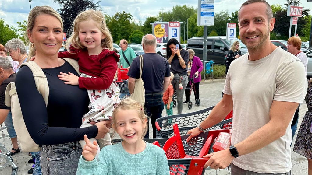 Stefanie und Cornelius Hoffmann aus Burg mit ihren Kindern Matilda und Amelie kurz vor der Eröffnung des Rewe-Supermarktes an der B1.