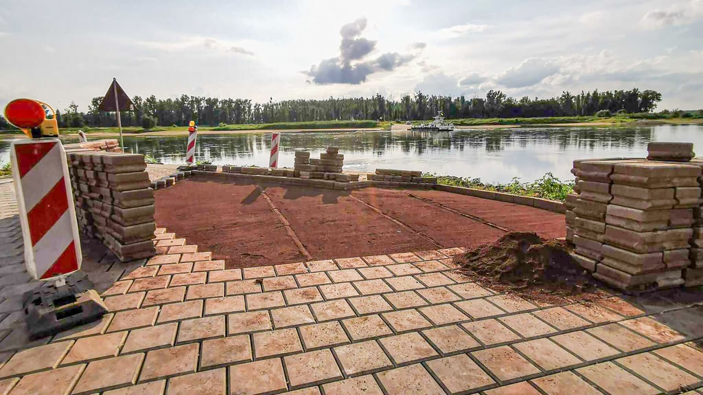 Eine Baufirma nimmt im Sommer 2025 Ausbesserungen am neu errichteten Anleger (Havelberg-Seite) der Räbeler Fähre vor.