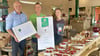 Wolfgang Hahn von der Agrarmarketing-Gesellschaft aus Magdeburg überbringt Marvin und Theresa Zwicker (alle v. li.) zwei Zeugnisse für den errungenen „Kulinarischen Stern 2025“, eine  Urkunde  für innen und das große Schild für die Außenfassade.