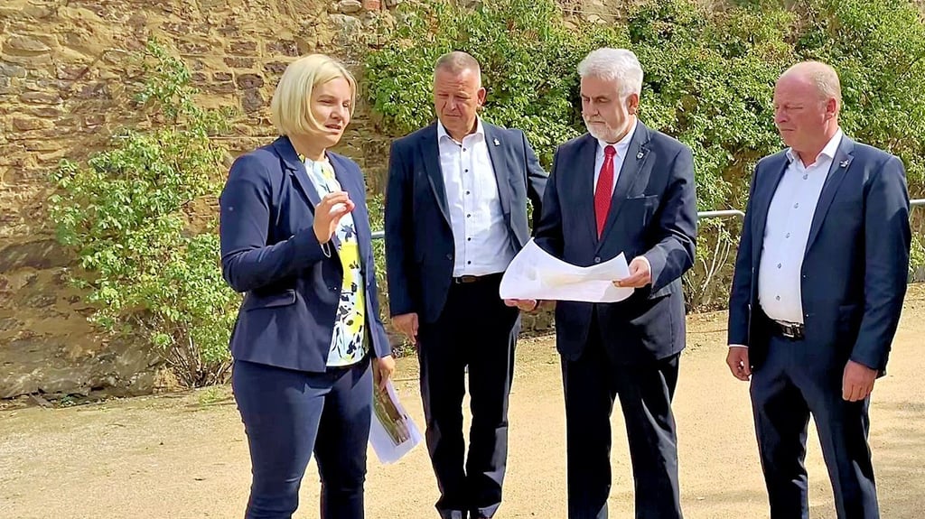 Energie und Umweltminister Armin Willingmann (2.v.r.) lässt sich von Stadtplanerin Nina Szebrowski im Beisein von Bürgermeister Bernhard Hieber (2.v.l.) und Holger Waldmann das geplante Klimabeet erklären.