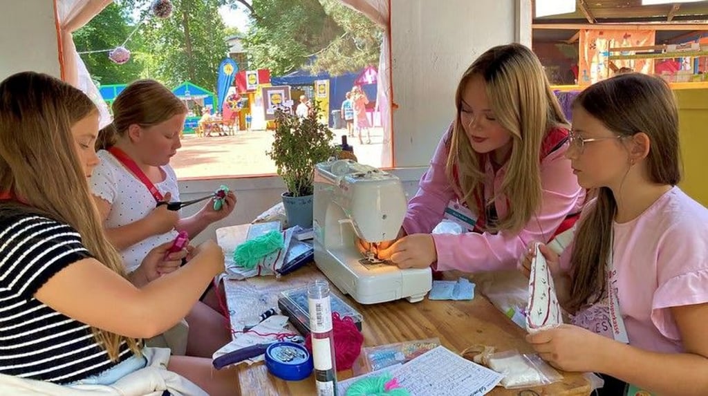 Die zehnjährigen Mädchen Johanna (von links), Anna und Ella (rechts) lernen bei der 16 Jahre alten Maja in der Kinderstadt-Schneiderei den Umgang mit einer Nähmaschine. Unter anderem wurden die Requisiten für das Theaterstück „3 kleine Schweinchen in Bärenhausen“ selbst geschneidert.