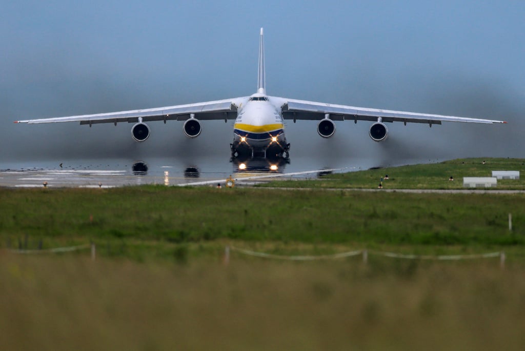 Eine Antonow 124 (An-124), eines der größten Frachtflugzeuge der Welt, spiegelt sich beim Start im Hitzeflimmern der Startbahn vom Flughafen Leipzig/Halle.