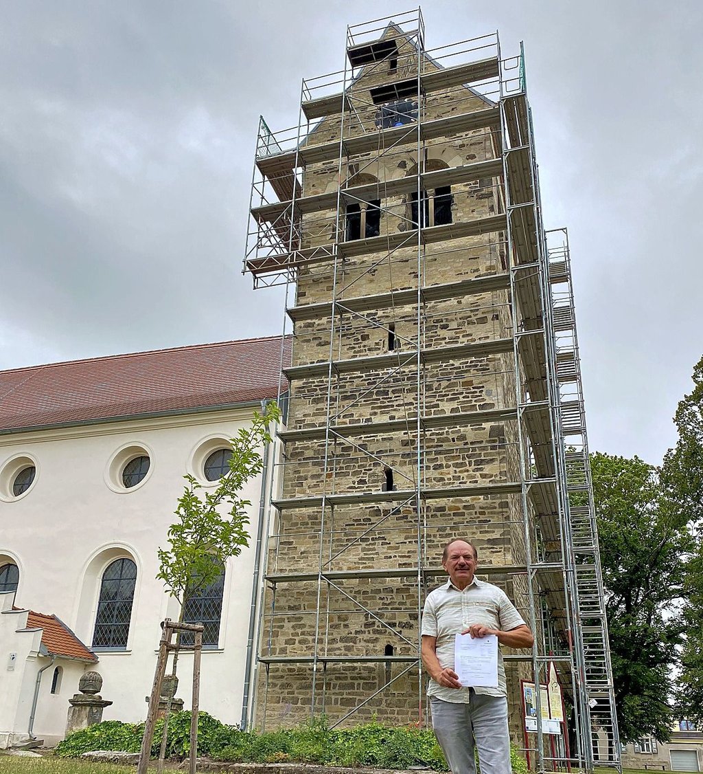 Bürgermeister Korn mit Förderungsbewilligung vor dem Turm.