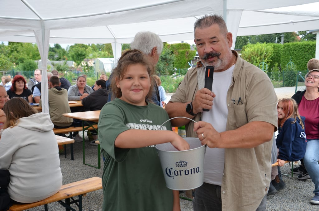 Glücksfee Mia zieht zum Sommerfest der Kleingartenanlage Salzwerke in Staßfurt die Gewinner aus dem Lostopf vom Vereinsvorsitzenden Ingo Knabe.
