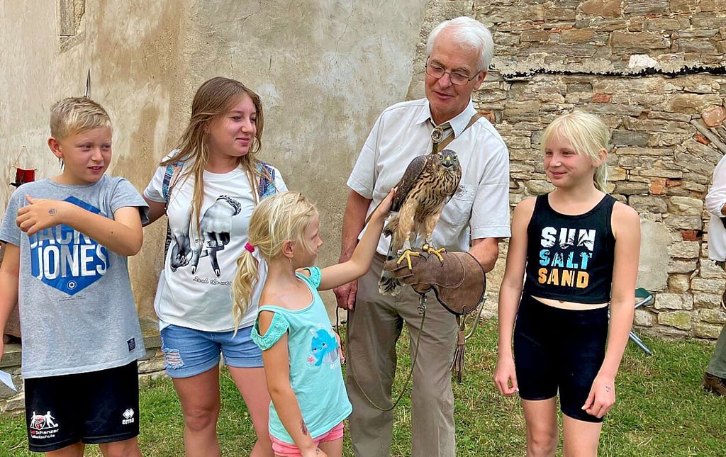 Die Kinder können bei Siegfried Kamprath Habichtweibchen „Erna" streicheln.