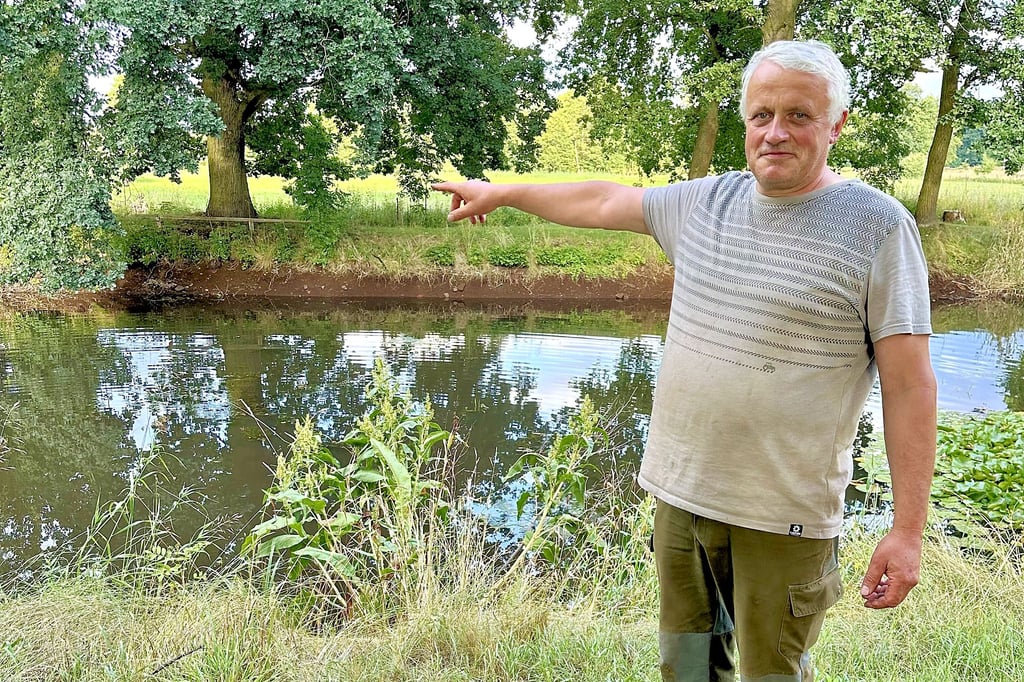 Trotz des Regens der vergangenen Tage: Landwirt Nils Rosenthal zeigt auf das Ufer des Schopsdorfer Dorfteiches, dessen Wasserstand deutlich zu niedrig ist.