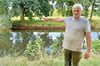 Trotz des Regens der vergangenen Tage: Landwirt Nils Rosenthal zeigt auf das Ufer des Schopsdorfer Dorfteiches, dessen Wasserstand deutlich zu niedrig ist. 