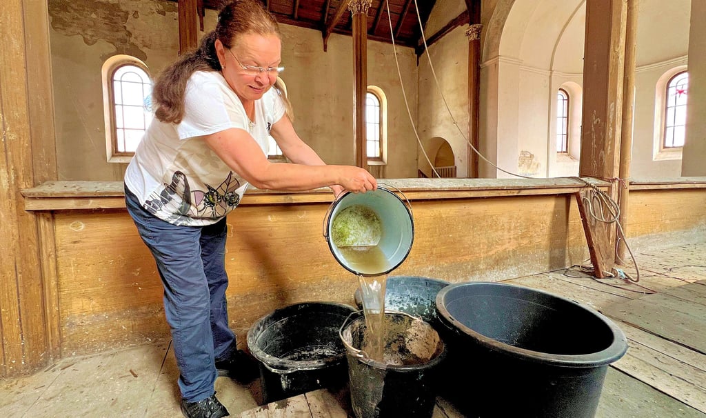 Rita Swillus fängt das Regenwasser mit Eimern auf.