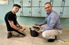 Burgs Bürgermeister Philipp Stark schaut sich mit Sven Hellwig (Firma Randel) das alte Fugenmaterial in der Schwimmhalle an.