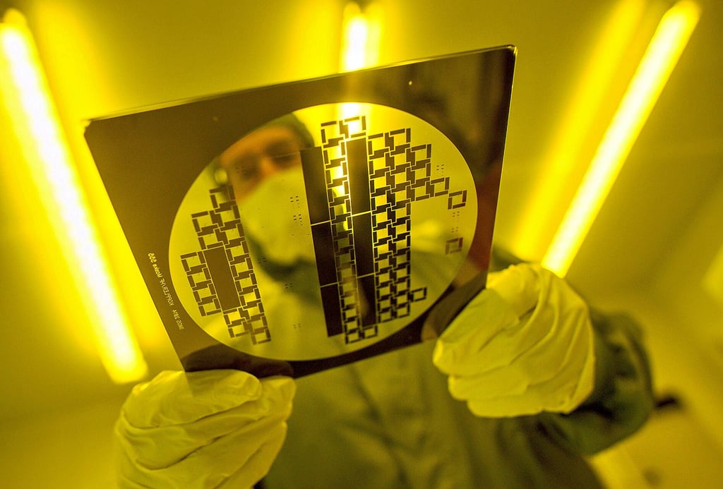 Ein Mann trägt in einem Reinraum eine sogenannte „Maske" zur Herstellung von Halbleiterstrukturen durch den Reinraum. Das Dresdner Unternehmen FMC plant in der Nähe von Magdeburg den Bau einer Chipfabrik.