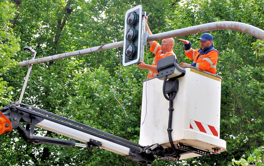 Robert Bauherr (links) von der Firma Swarco bringt in Stendal an der Kreuzung Parkstraße/Ostwall eine von vier neuen Ampeln an. Sein Kollege überprüft die Ausrichtung.