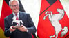 Doppelt im Bild: Pferde auf der Krawatte und eines in der Hand. Bundeskanzler Merz mit Gastgeschenk in der Staatskanzlei.