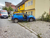 Das Fahrzeug reißt einen Baum um und kommt kurz vor einer Hauswand zum Stehen.