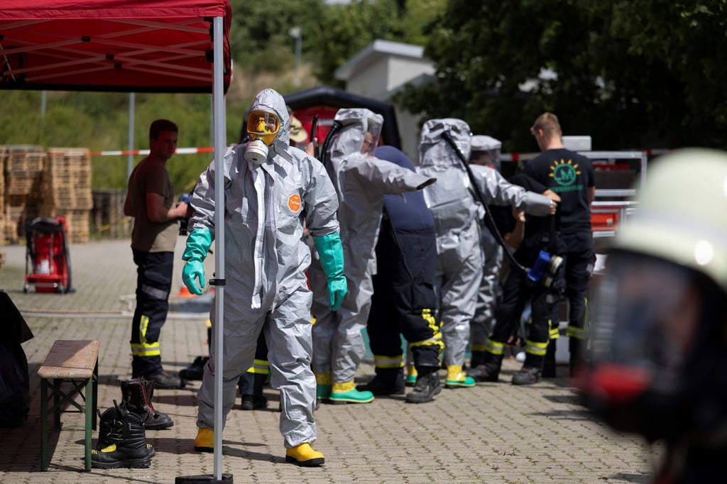 Einsatzkräfte in speziellen Schutzanzügen sind im Einsatz.